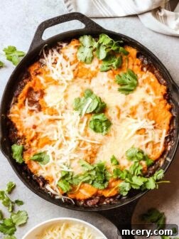 Overview sweet potato shepherd's pie in black cast iron skillet, garnished with cilantro