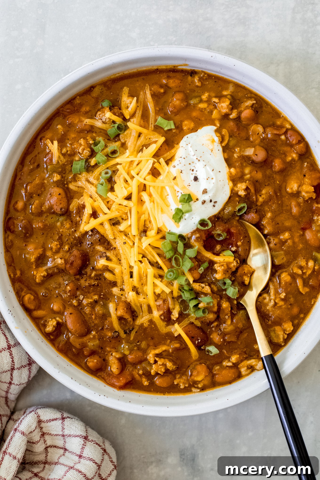 Pumpkin Harvest Turkey Chili 2 turkey pumpkin chili in a bowl with cheese and green onions.