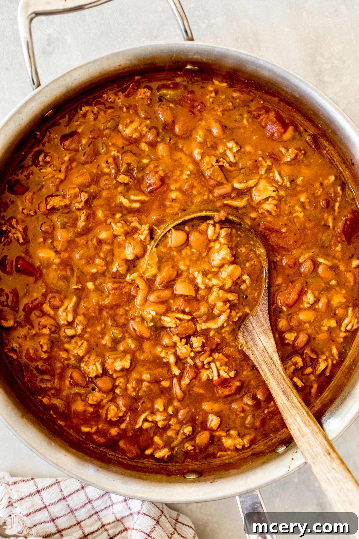 Pumpkin Harvest Turkey Chili 8 pumpkin chili in a dutch oven with wooden ladle on the side.