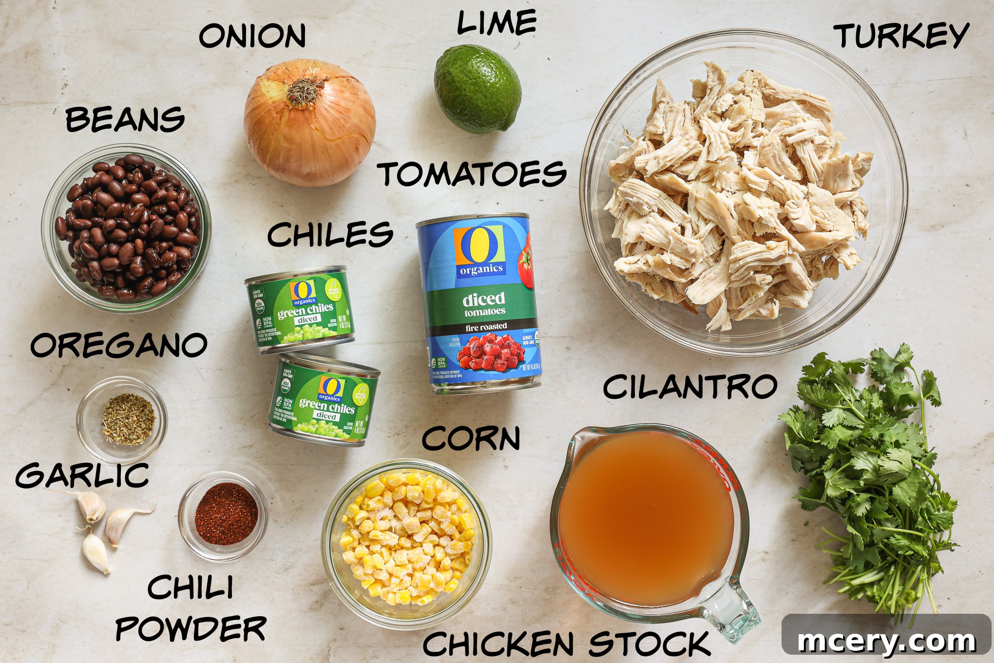 Hearty Turkey Tortilla Soup 3 A rustic wooden board displaying fresh ingredients for tortilla soup, including diced turkey, corn, beans, and spices.