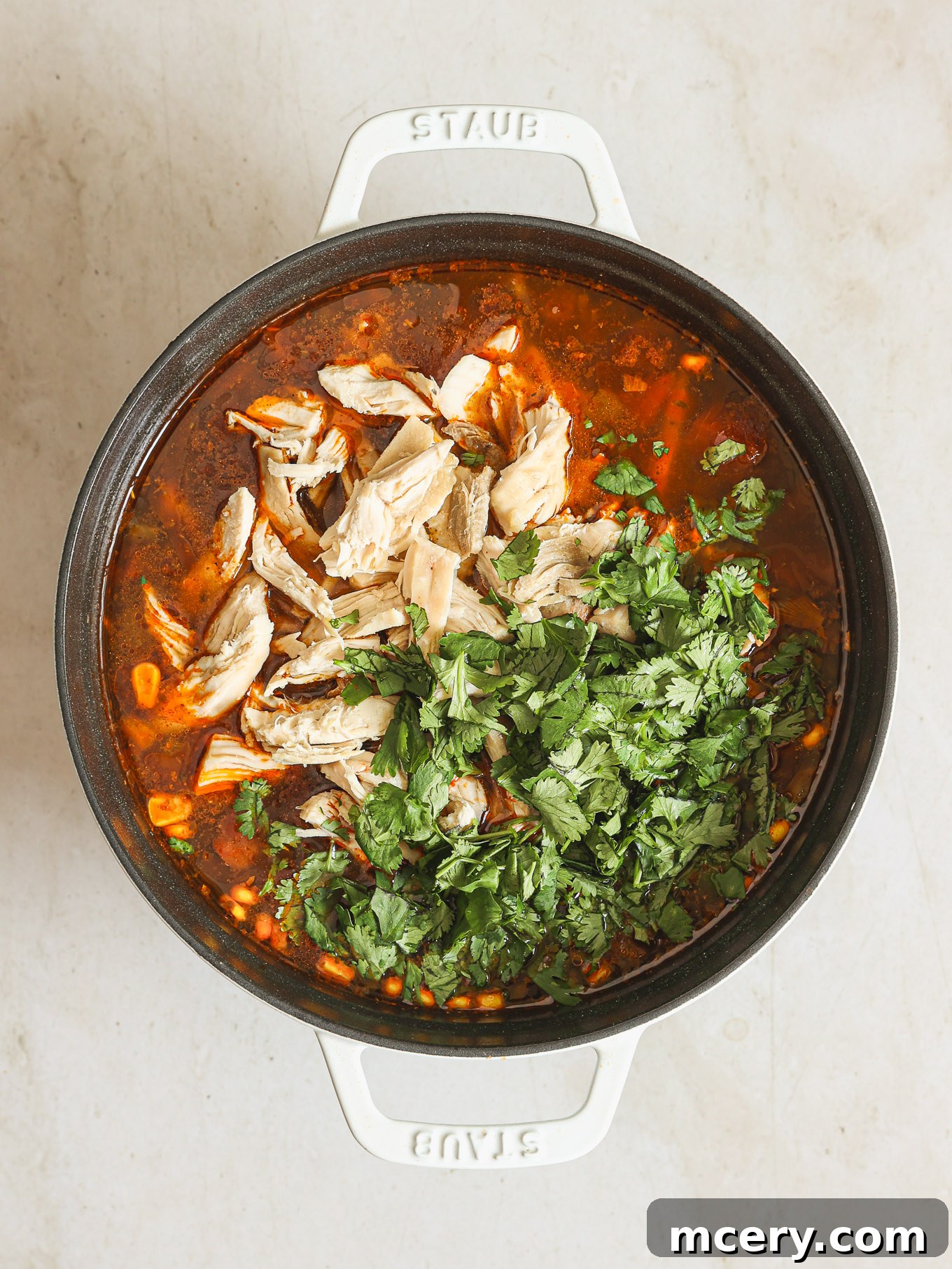 Hearty Turkey Tortilla Soup 6 Shredded turkey meat and fresh cilantro being stirred into the simmering soup.