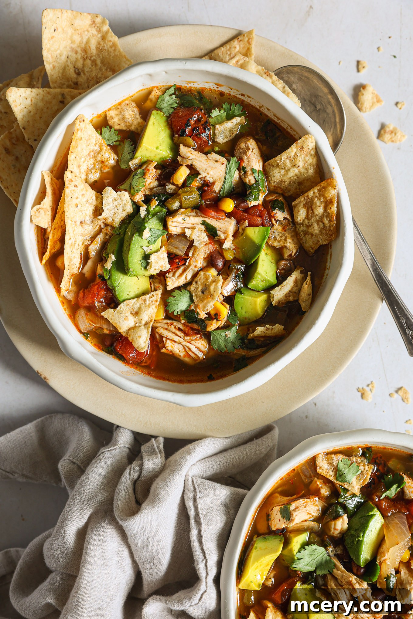 Hearty Turkey Tortilla Soup 8 A bowl of turkey tortilla soup, garnished with vibrant green avocado cubes and a sprinkle of cilantro.