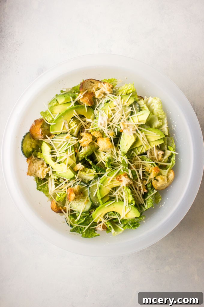 Lush Avocado Caesar 9 The fully assembled Caesar salad, adorned with fresh avocado slices, additional croutons, and a generous sprinkle of Parmesan cheese.