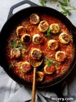 Healthy chicken meatballs in marinara sauce in black cast-iron skillet