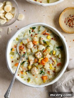 A bowl of creamy scallop chowder garnished with fresh parsley.