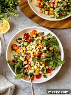 Overhead greek chickpea salad in white bowl on gray background