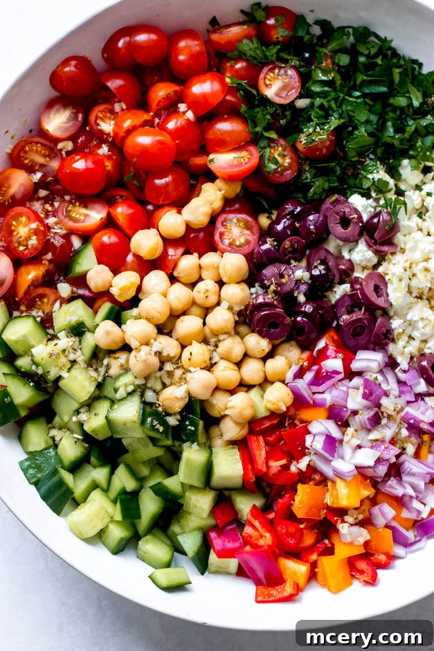 Vibrant Mediterranean Chickpea Salad 3 Close-up side view of a generously portioned Greek Chickpea Salad, highlighting the crisp vegetables, creamy feta, and the rich texture of chickpeas.
