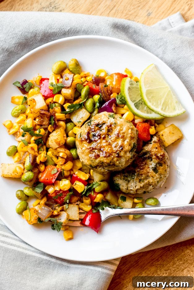 Homestyle Chicken Patties with Bright Corn Succotash 6 Chicken patties over corn succotash on a white plate