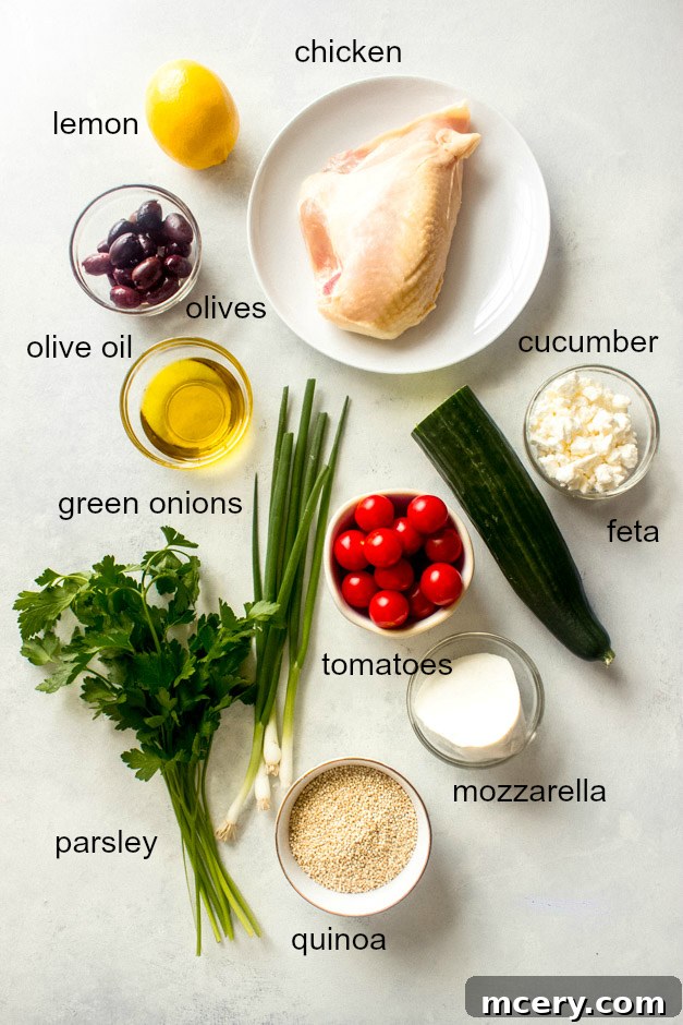 Vibrant Lemon Chicken Quinoa Bowl 3 A flat lay photograph showcasing all the fresh ingredients for a lemon chicken quinoa salad, including chicken breast, quinoa, various vegetables, herbs, and cheeses.
