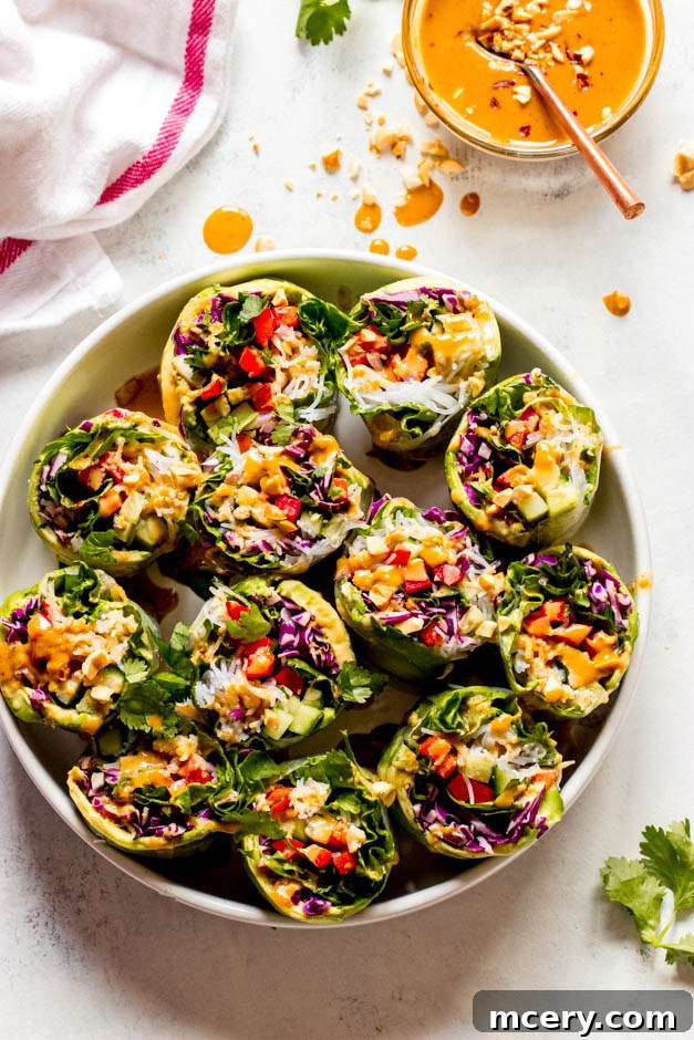 Easy Homemade Veggie Rolls 2 Beautifully arranged rice paper rolls with colorful vegetables on a white platter, ready to be served with dipping sauce.