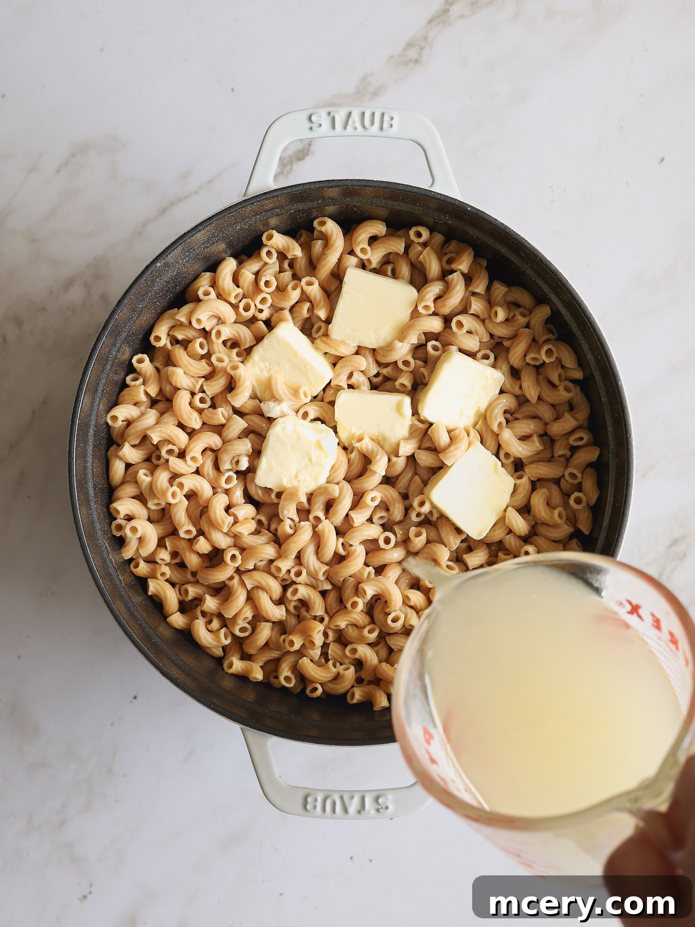 Guilt Free Whole Wheat Mac and Cheese 4 Cooked whole wheat macaroni mixed with melted butter in a Dutch oven.