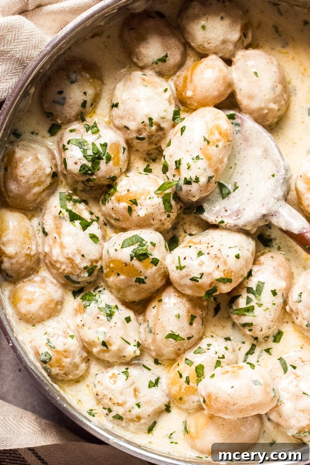 Close up shot of creamy baby potatoes drenched in velvety garlic parmesan cream sauce