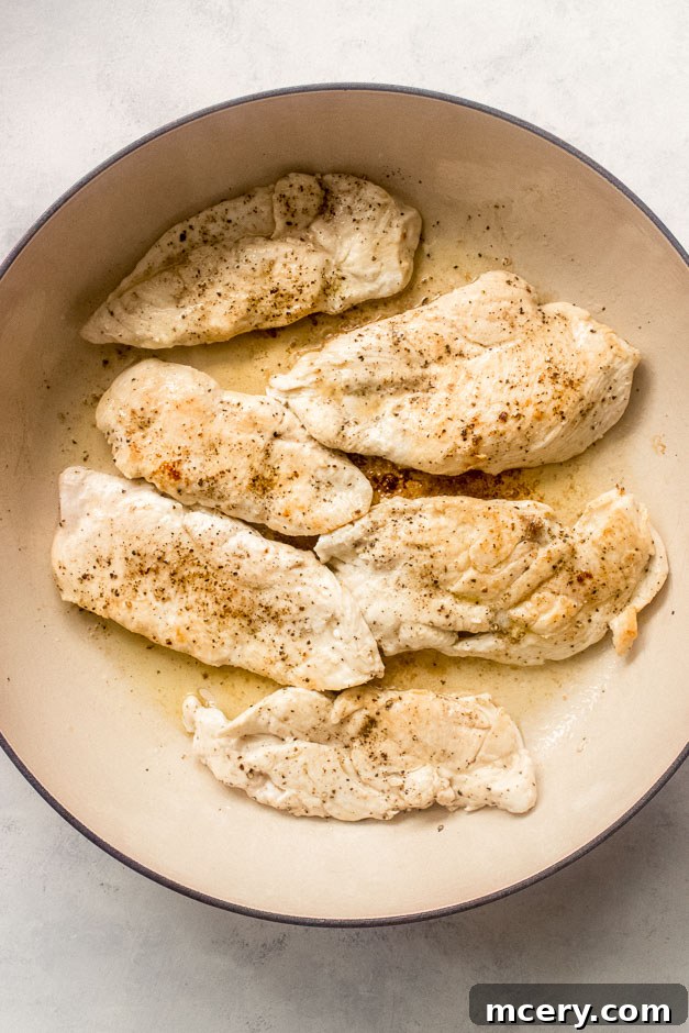 Creamy Coconut Chicken Skillet 6 Seared golden-brown chicken breast cooking in a large sauté pan.