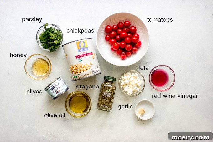 Mediterranean Sunshine Chickpea Salad 3 Individual ingredients laid out for chickpea tomato salad, including chickpeas, tomatoes, olives, feta, and parsley.
