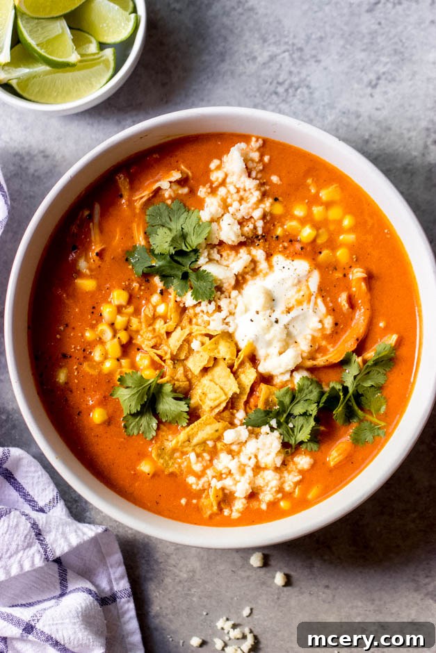 Velvety Chicken Tortilla Soup 2 Close up of a bowl of creamy chicken tortilla soup garnished with fresh cilantro and crushed tortilla chips, highlighting the smooth texture.