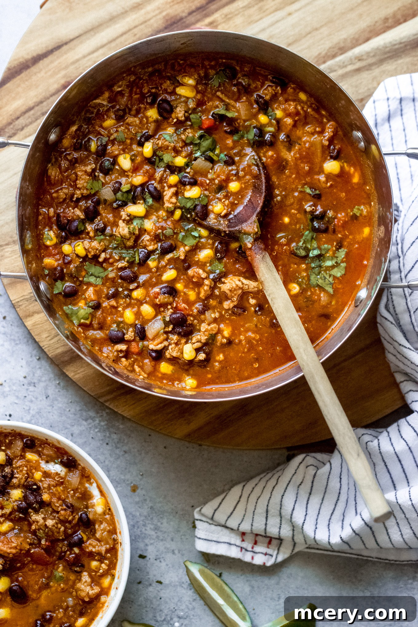 Wholesome Turkey Quinoa Chili 2 turkey chili in a pot with a wooden spoon. A cozy, hearty meal for any day.