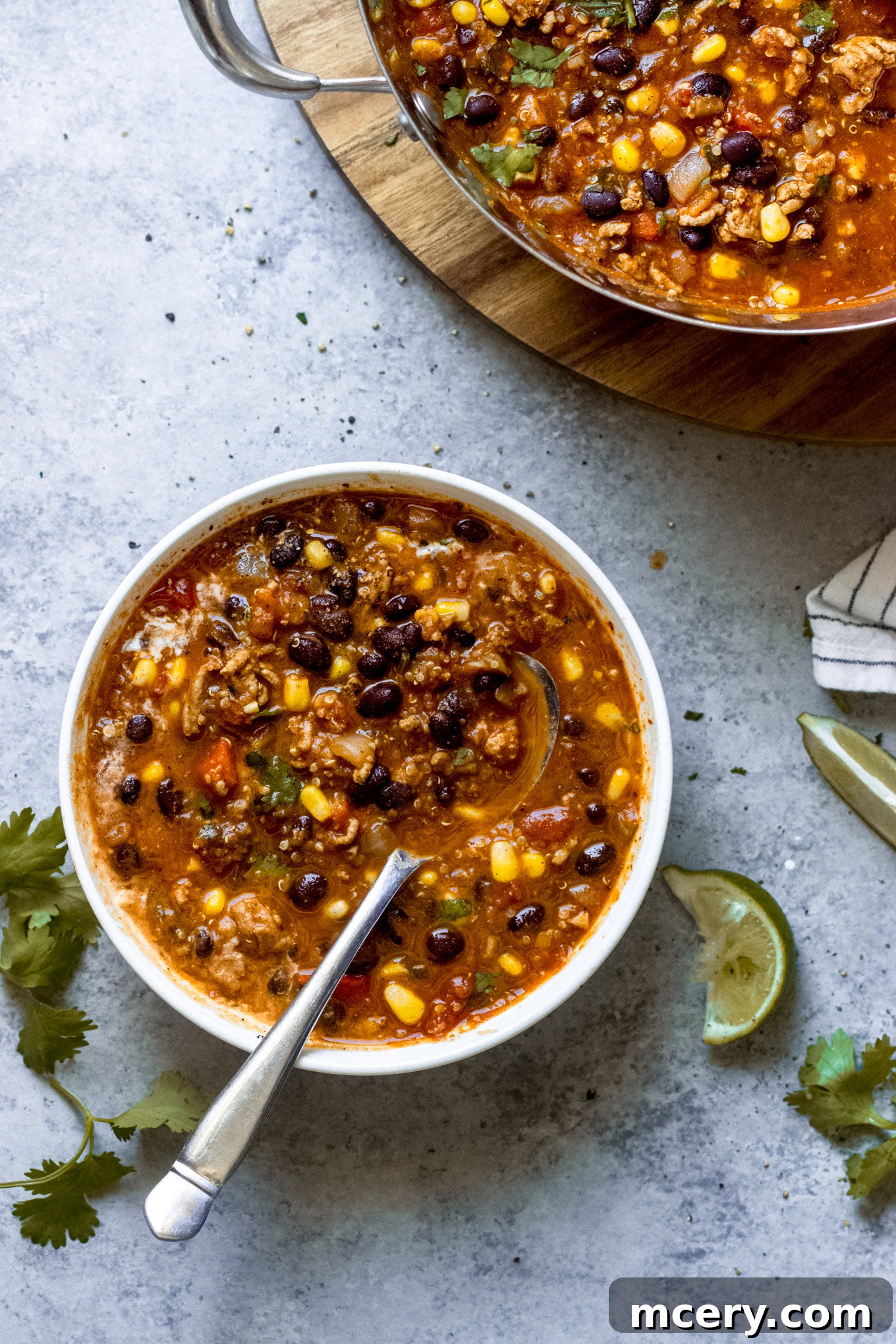 Wholesome Turkey Quinoa Chili 4 A steaming bowl of smoky turkey quinoa chili with a spoon, ready to be enjoyed as a hearty meal.