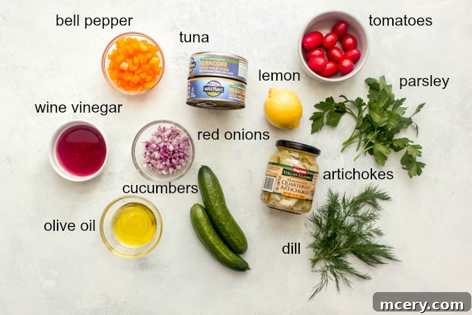 Sun-Kissed Mediterranean Tuna Salad 3 Assorted fresh ingredients for Mediterranean tuna salad laid out on a surface.