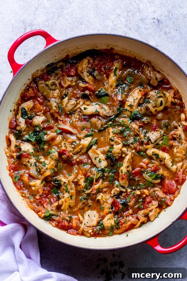 Velvety Tomato Chicken Delight 2 Creamy tomato chicken recipe served in a vibrant red sauté pan, garnished with fresh herbs.