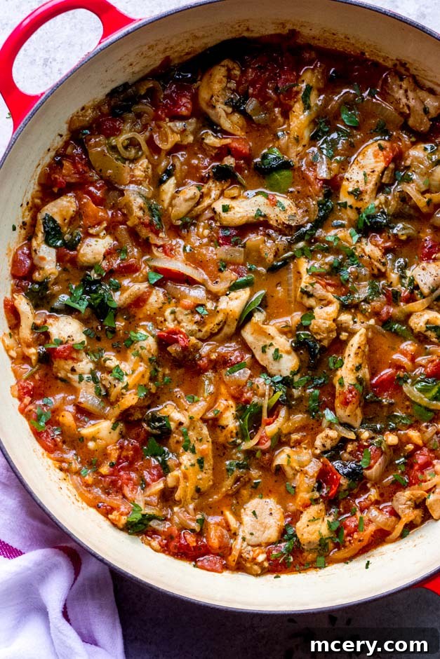 Velvety Tomato Chicken Delight 3 Close-up shot of creamy chicken spinach tomato recipe simmering in a sauté pan.