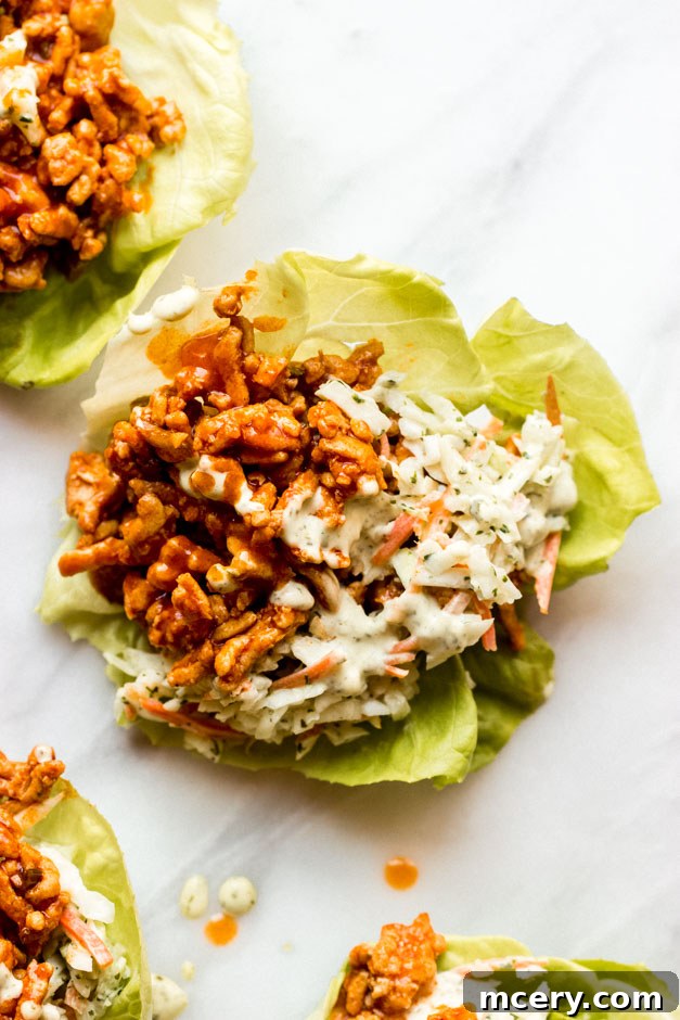 Close-up of a completed buffalo chicken lettuce wrap with creamy slaw.
