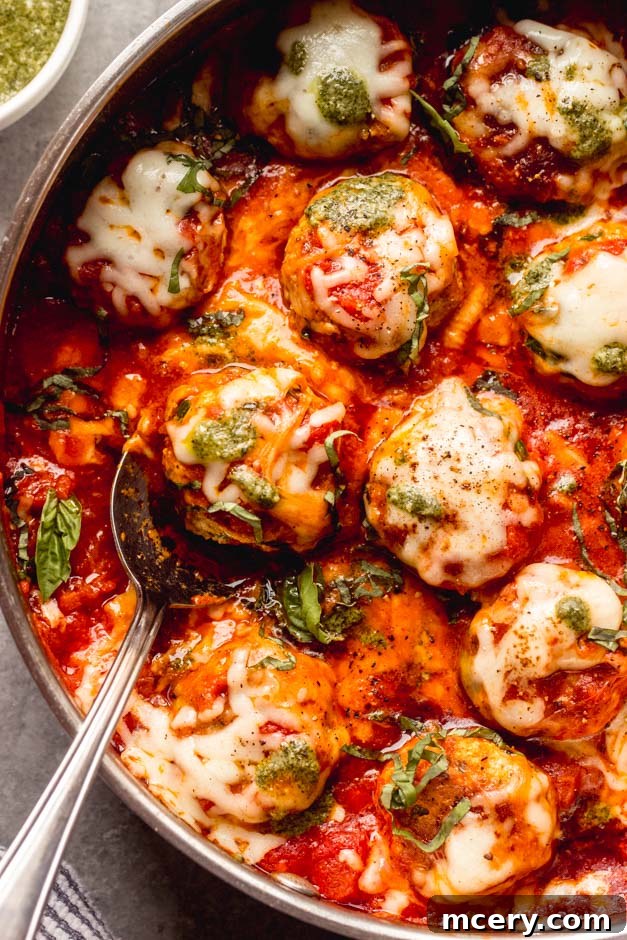 pesto meatballs simmering in a skillet