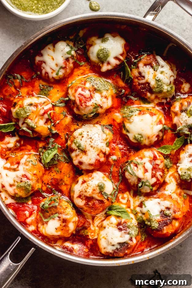 pesto meatballs with turkey and spinach in a skillet with melted cheese