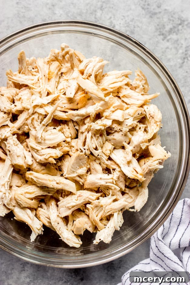 Succulent Oven Roasted Bone-In Chicken Breast 8 Close-up of perfectly shredded roasted chicken breast in a glass bowl, ready for endless culinary possibilities.