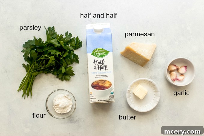 All six ingredients for the garlic cream sauce laid out on a cutting board: butter, garlic, flour, half and half, Parmesan, and parsley.