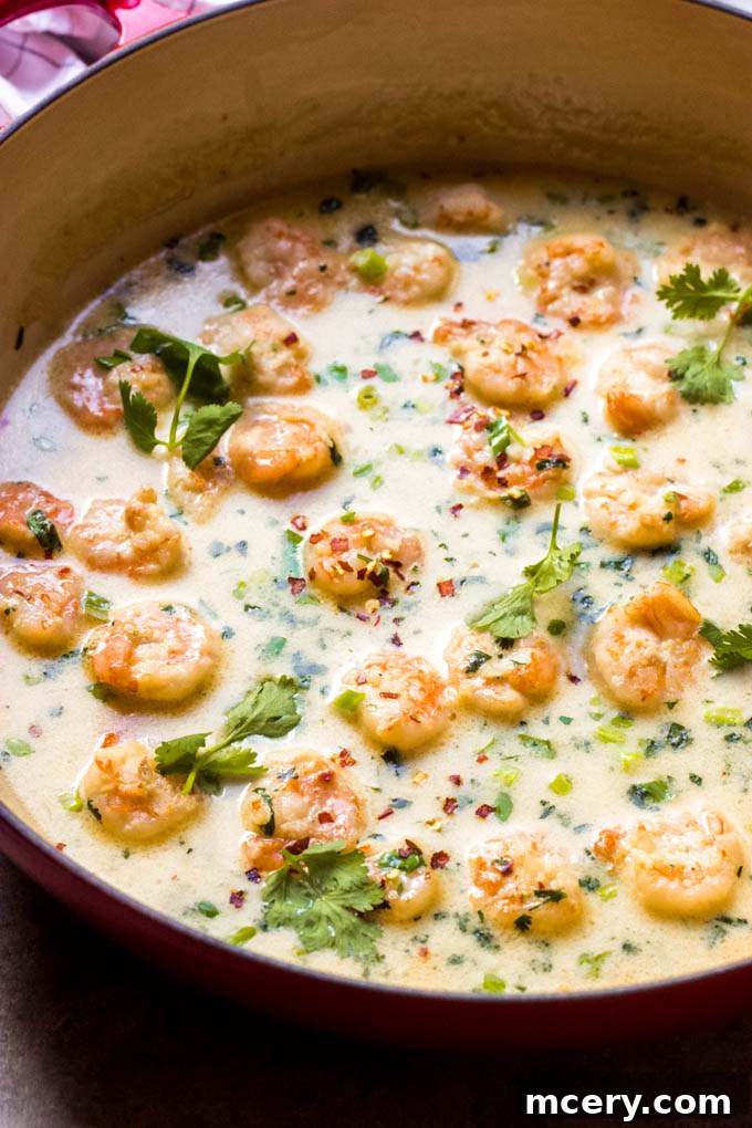 Velvety Coconut Shrimp Sensation 8 A close-up of the finished coconut milk shrimp dish with a spoon, highlighting its creamy sauce and fresh garnishes