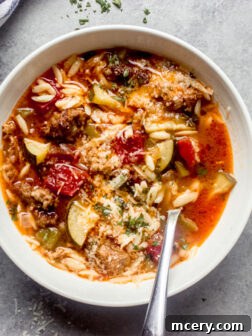 Overhead view of a bowl of zucchini sausage soup, garnished and ready to be enjoyed, highlighting its comforting and delicious nature.