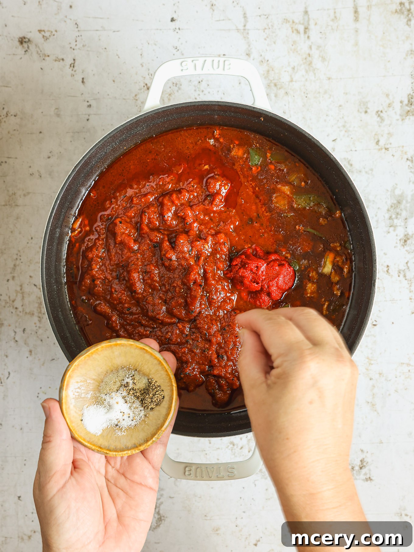 Hearty Three Bean Turkey Chili 6 Crushed tomatoes and tomato paste mixed into the chili base, creating a rich, red sauce in the pot.