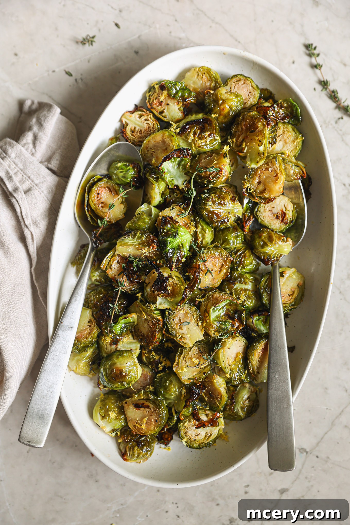 A vibrant oval platter brimming with perfectly roasted Brussels sprouts, glistening with maple glaze.