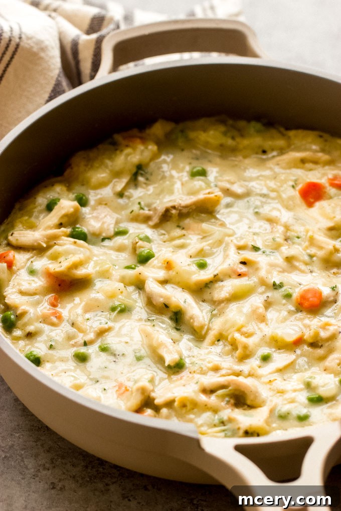 Close-up of a generous serving of crustless chicken pot pie, highlighting its rich, creamy texture and ingredients