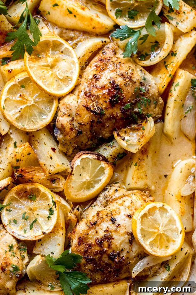 Zesty Lemon Herb Roasted Chicken and Golden Potatoes 9 Close-up of a serving of lemon roasted chicken and potatoes, showing the crispy skin and tender interior, garnished with fresh parsley