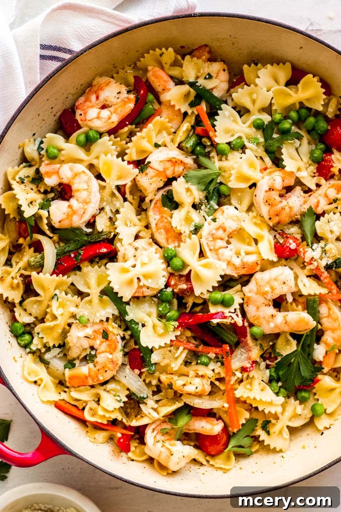 Zesty Shrimp and Spring Vegetable Pasta 8 Close-up of a serving of Shrimp Pasta Primavera, garnished with fresh parsley and Parmesan cheese.