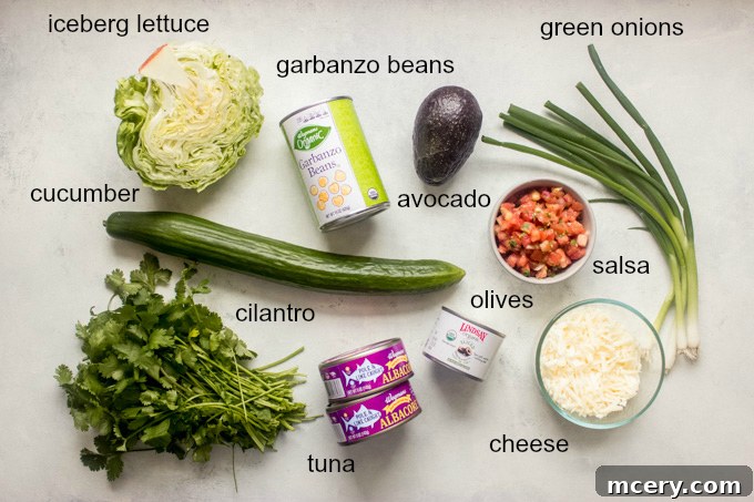 Zesty Mexican Tuna Salad with Cilantro Cream 4 Assortment of fresh ingredients laid out for Mexican tuna salad, including lettuce, cucumber, tuna cans, beans, and avocado.