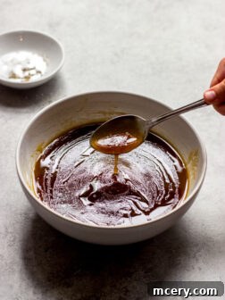A small bowl of fresh salad with a serving of balsamic vinaigrette on the side.