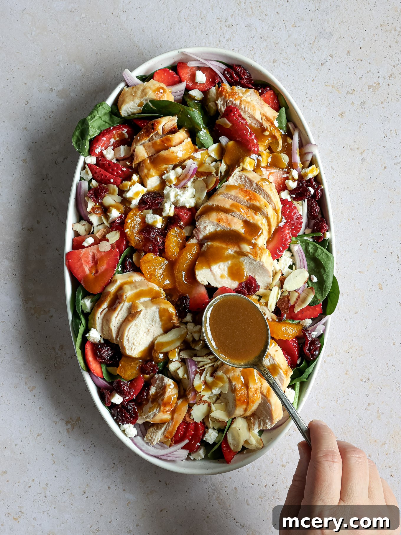 Vibrant Strawberry Chicken Salad 6 A stream of rich balsamic dressing being drizzled generously over the assembled strawberry spinach chicken salad.