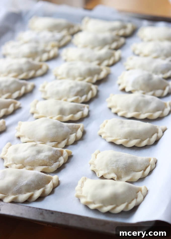 Pillowy Potato Pierogi 3 Close-up of homemade potato perogies, showcasing the tender dough and savory filling ingredients like potato, bacon, and dill.