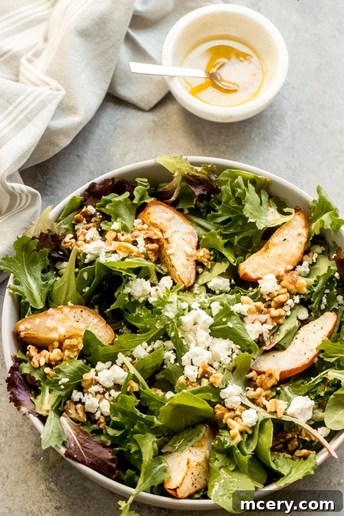 Caramelized Pear & Chevre Salad 7 Overhead shot of the finished roasted pear salad with goat cheese, walnuts, and lemon vinaigrette artfully arranged on a large white platter, ready for serving