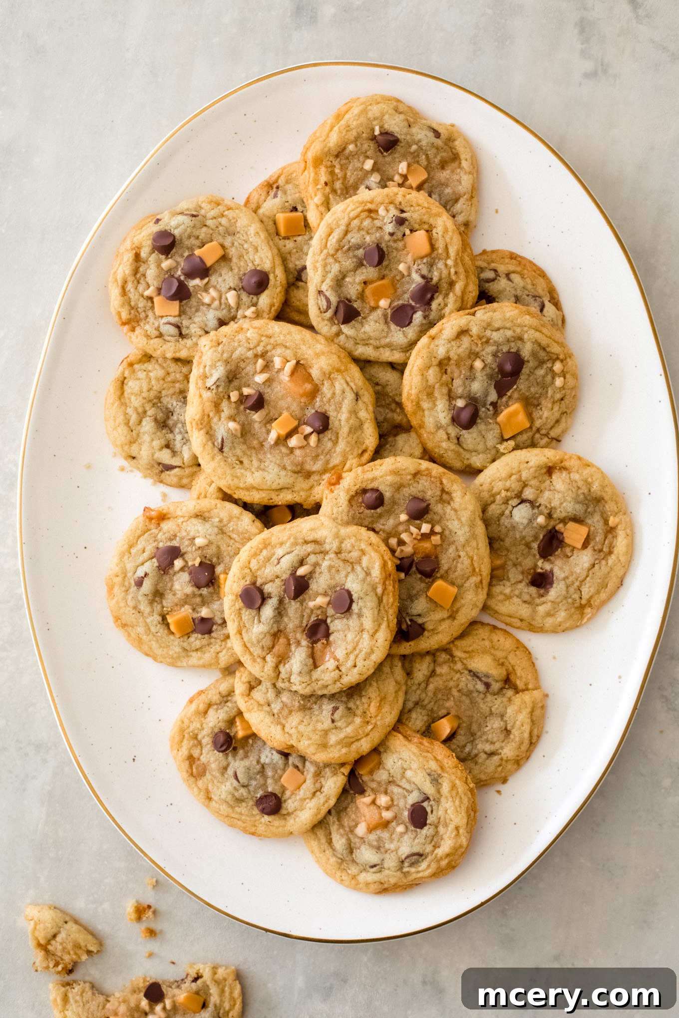 Close-up of baked caramel chocolate cookies on a white plate, highlighting the melted chocolate and caramel.