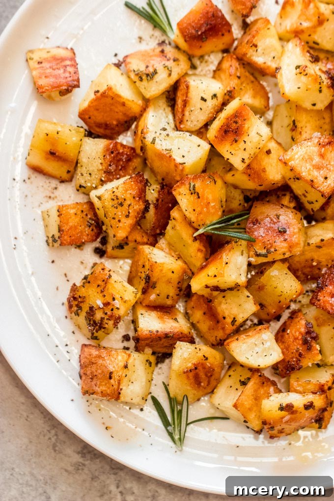 Crispy Rosemary Roasted Potatoes 3 close up roasted garlic and rosemary potatoes garnished with fresh rosemary.