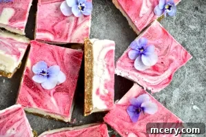 Stacked No-Bake Lemon Raspberry Bars, showing the thickness of the creamy filling and crust, garnished with fresh berries.