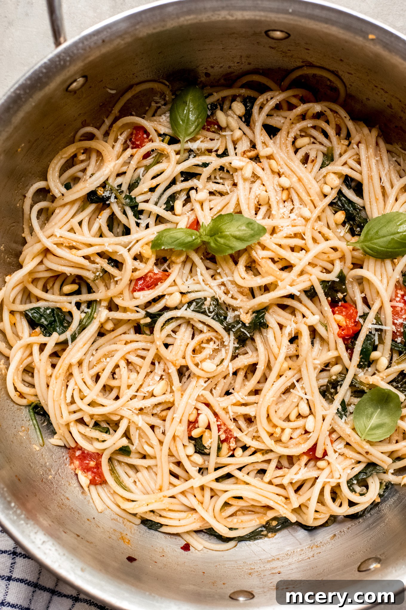 Garden Fresh Spinach and Tomato Pasta 2 spaghetti with tomatoes and spinach in a saute pan.