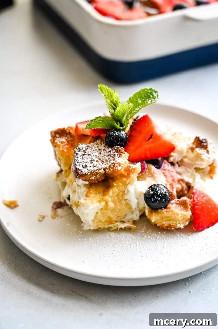 Creamy Berry Baked French Toast 3 A close-up of a baking dish filled with Berries and Cream French Toast Bake, showcasing the layers of brioche, berries, and cream cheese.