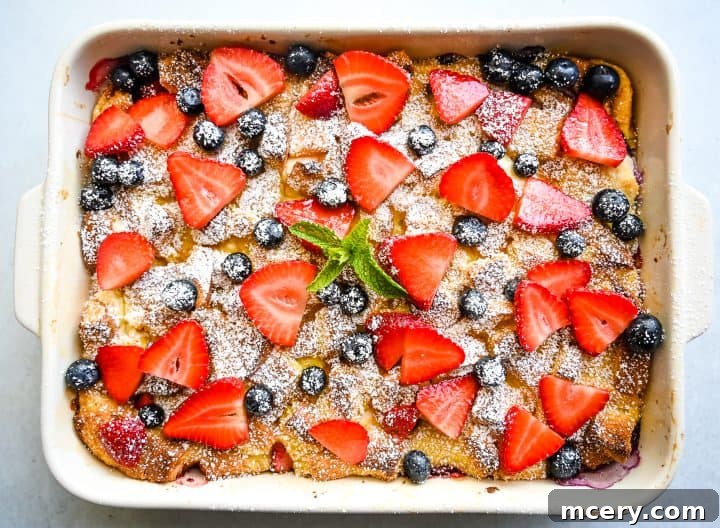 Creamy Berry Baked French Toast 5 A large rectangular Berries and Cream French Toast Bake in a white baking dish, freshly baked and ready to serve.