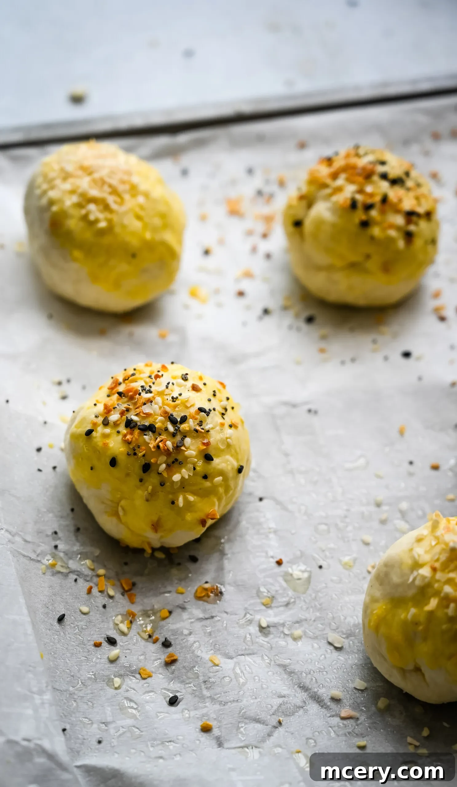 Bagel Bombs 11 A hand sprinkling 'everything but the bagel' seasoning over unbaked stuffed bagel bites.
