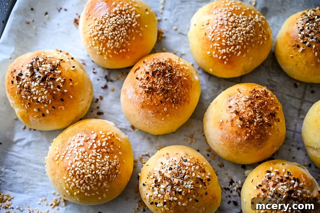 Bagel Bombs 12 Freshly baked golden brown stuffed bagel bites on a baking sheet, glistening with egg wash.