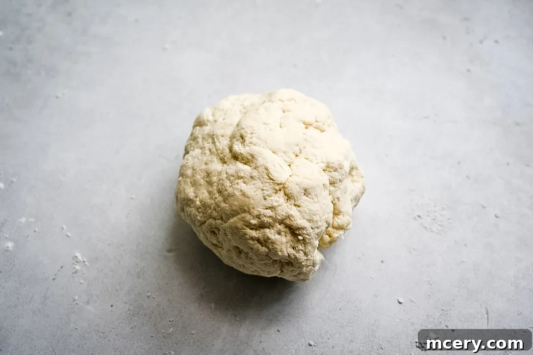 Bagel Bombs 7 A flattened piece of two-ingredient dough with a cube of cream cheese placed in the center.